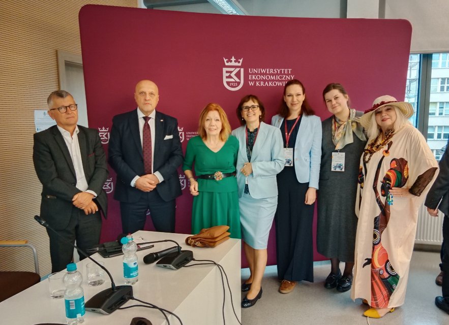Zdjęcie grupowe organizator&oacute;w konferencji, w tle ściana z logiem UEK