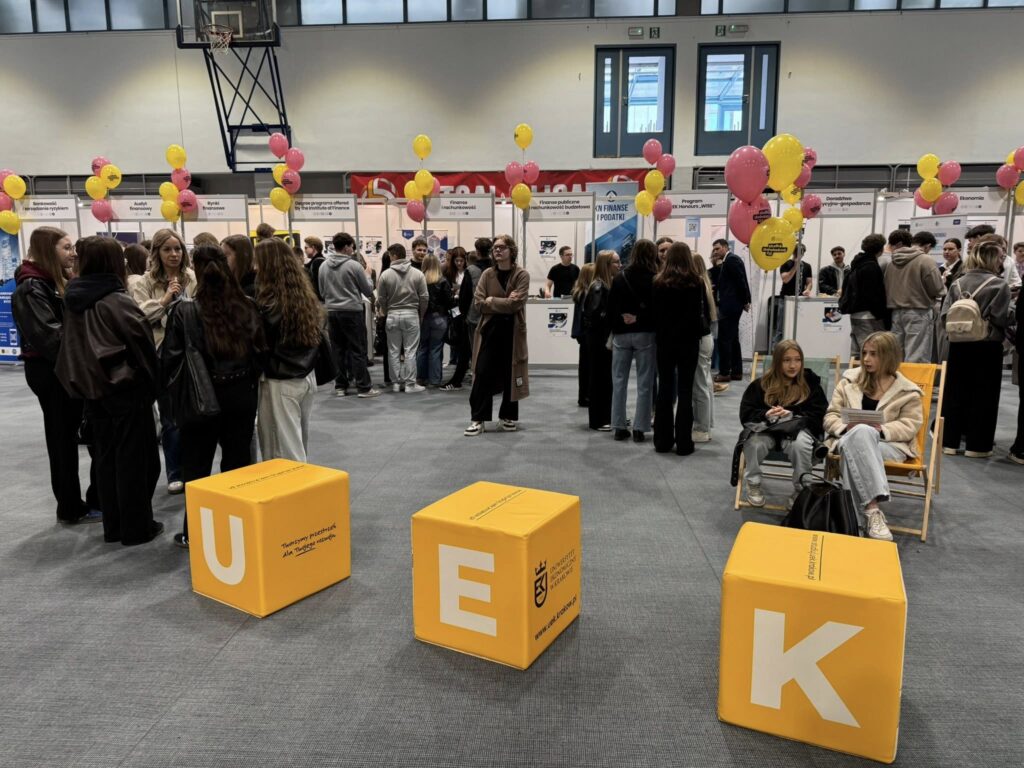 Grupa młodzieży na Dniach Otwartych, z przodu siedziska z napisem UEK.